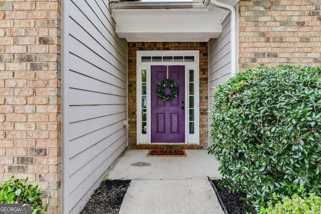 doorway to property with brick siding