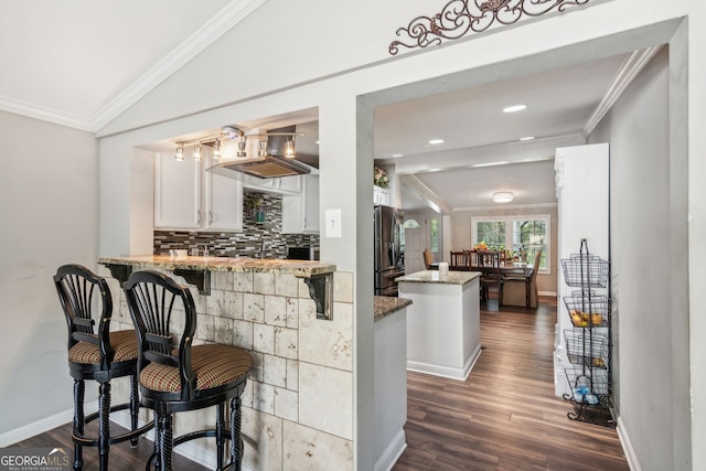 bar with ornamental molding, light stone countertops, lofted ceiling, white cabinets, and dark hardwood / wood-style flooring