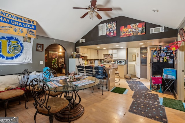 dining area with ceiling fan, high vaulted ceiling, and light hardwood / wood-style floors