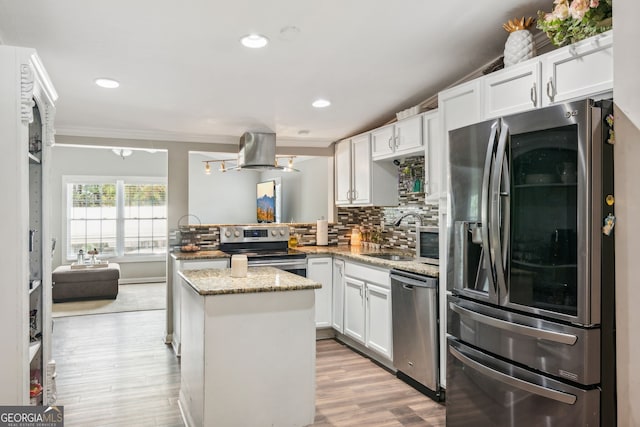 kitchen with sink, appliances with stainless steel finishes, decorative backsplash, light stone counters, and light hardwood / wood-style floors