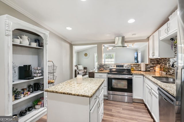 kitchen with light wood-type flooring, white cabinetry, appliances with stainless steel finishes, and a kitchen island