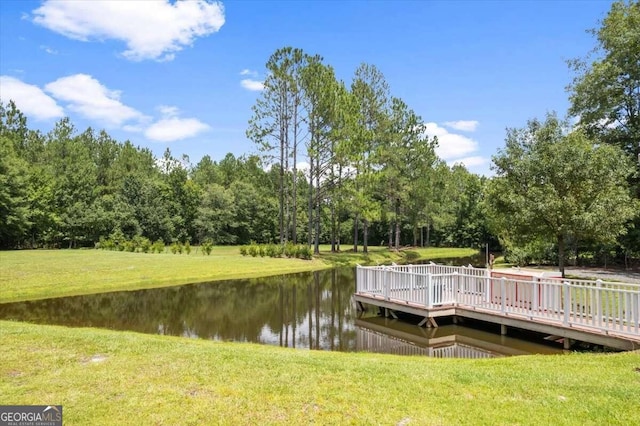 view of dock featuring a water view and a yard