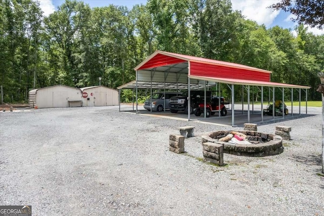 view of vehicle parking featuring a storage unit, gravel driveway, and a detached carport