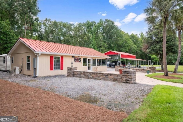 exterior space featuring metal roof, a standing seam roof, and driveway