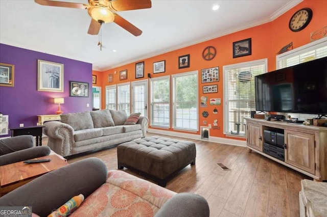 living room with ornamental molding, a wealth of natural light, and light wood-style floors