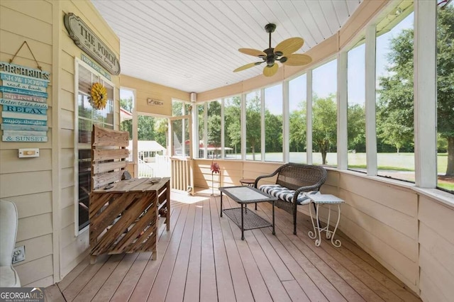 sunroom / solarium with wooden ceiling, a ceiling fan, and a healthy amount of sunlight