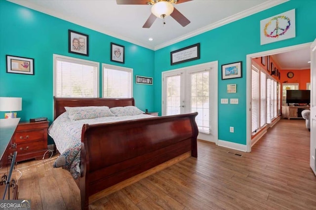 bedroom with baseboards, light wood finished floors, multiple windows, and crown molding