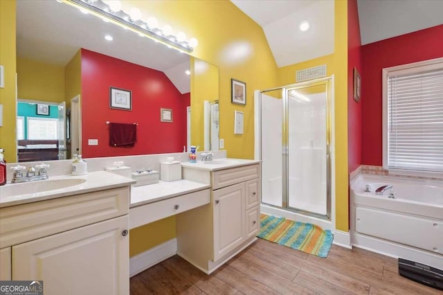 bathroom with wood finished floors, vaulted ceiling, a shower stall, and a bath