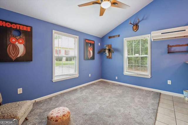 empty room with a wall unit AC, baseboards, a ceiling fan, and lofted ceiling