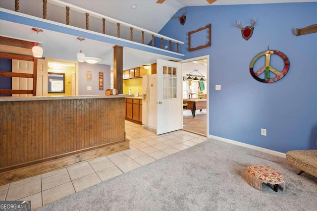 kitchen with pendant lighting, light tile patterned floors, light carpet, vaulted ceiling, and white fridge with ice dispenser