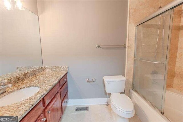 full bathroom featuring tile patterned flooring, combined bath / shower with glass door, toilet, and vanity