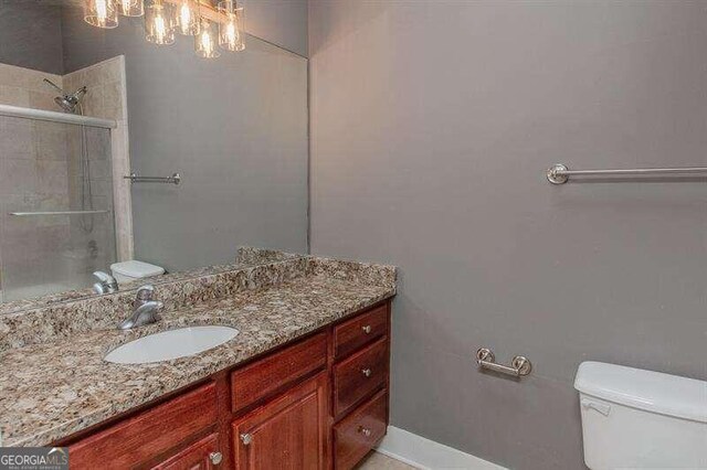 bathroom with walk in shower, toilet, and vanity