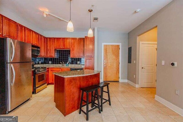 kitchen featuring light tile patterned flooring, a breakfast bar, backsplash, stainless steel appliances, and pendant lighting