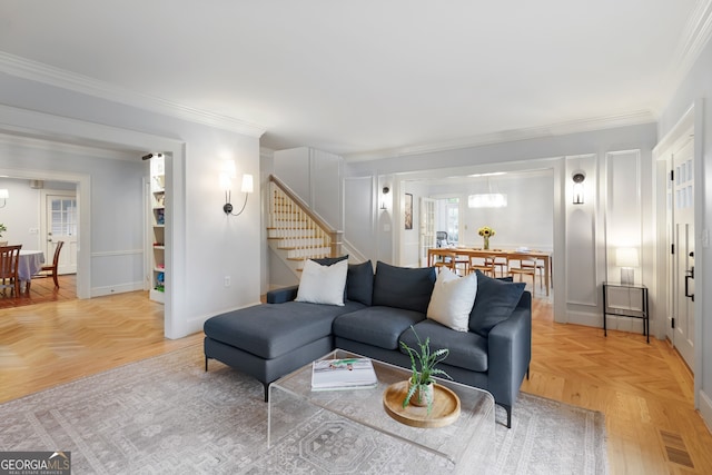 living room with ornamental molding and light parquet floors