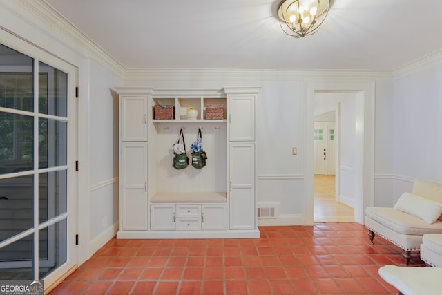 mudroom with tile patterned floors, crown molding, and a chandelier