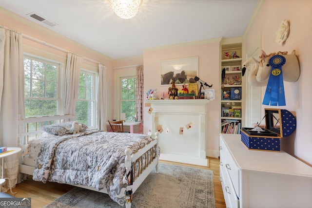 bedroom with crown molding, multiple windows, and light hardwood / wood-style flooring