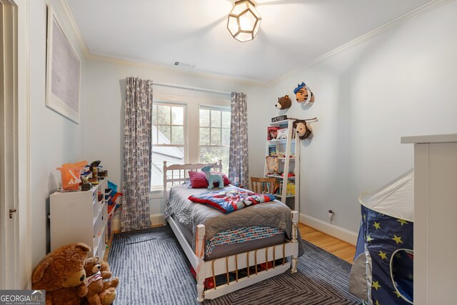 bedroom with wood-type flooring and crown molding