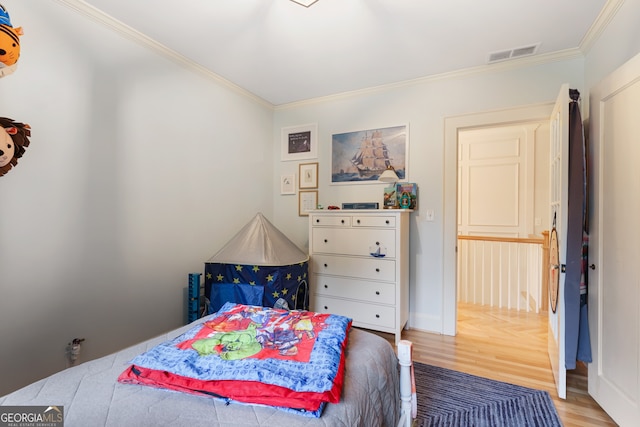 bedroom with light hardwood / wood-style flooring and crown molding