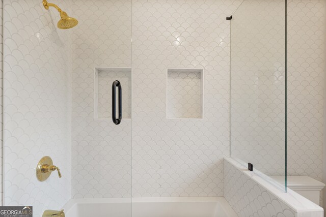 bathroom featuring tiled shower / bath combo and toilet