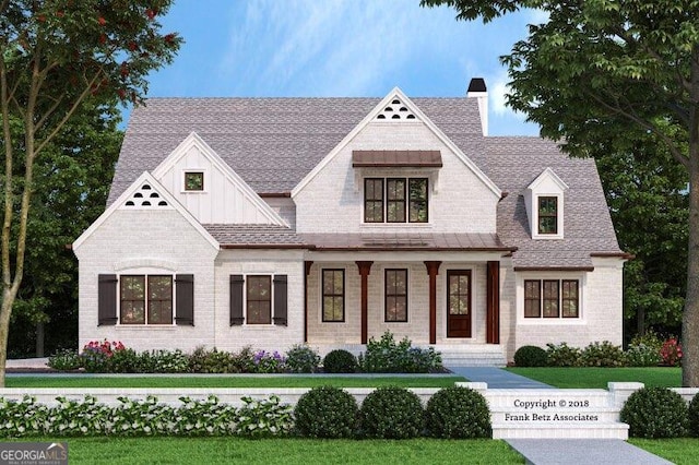 view of front facade featuring brick siding, a chimney, a shingled roof, board and batten siding, and a front lawn