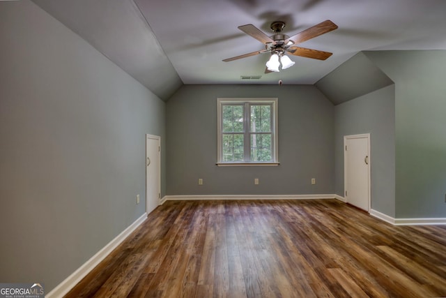 bonus room featuring ceiling fan, dark wood-type flooring, visible vents, baseboards, and vaulted ceiling