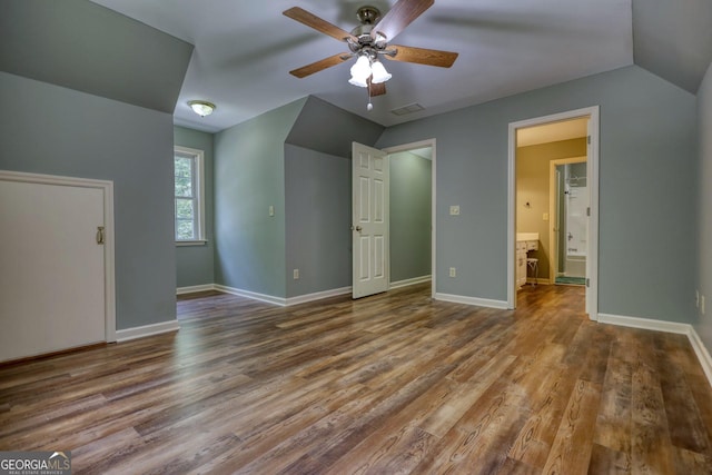 unfurnished bedroom featuring wood-type flooring, vaulted ceiling, connected bathroom, and ceiling fan