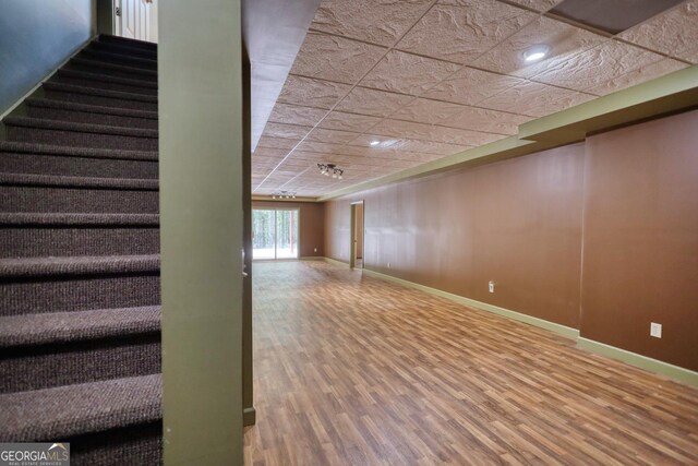 basement featuring hardwood / wood-style flooring and a paneled ceiling