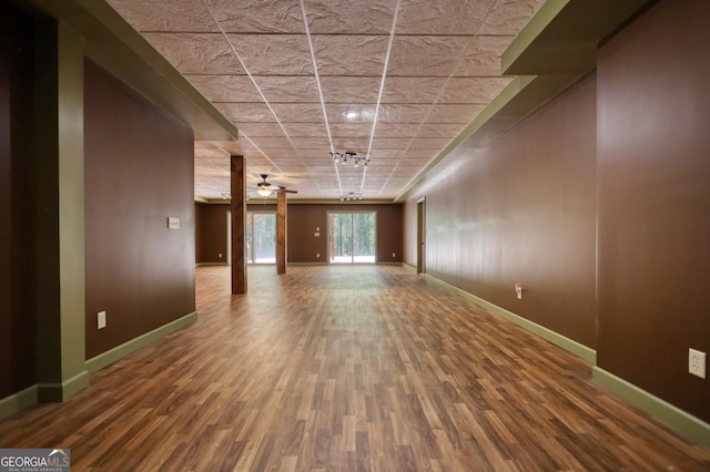 unfurnished living room featuring a ceiling fan, baseboards, and wood finished floors