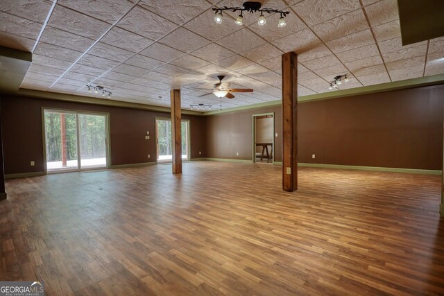 interior space featuring ceiling fan, hardwood / wood-style flooring, and a drop ceiling