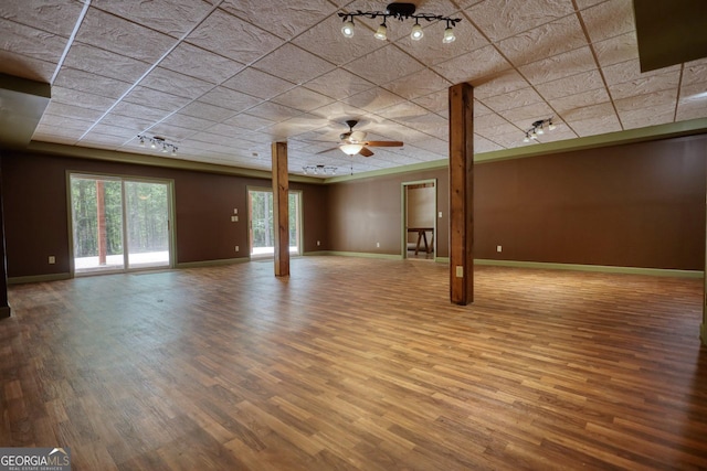 interior space featuring a ceiling fan, track lighting, baseboards, and wood finished floors