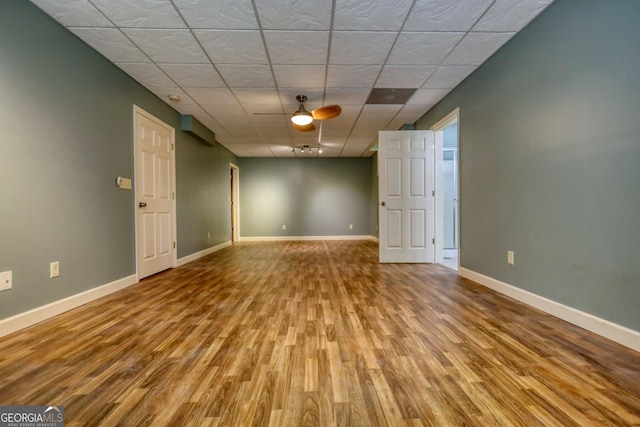 spare room with a paneled ceiling, light wood-type flooring, and ceiling fan