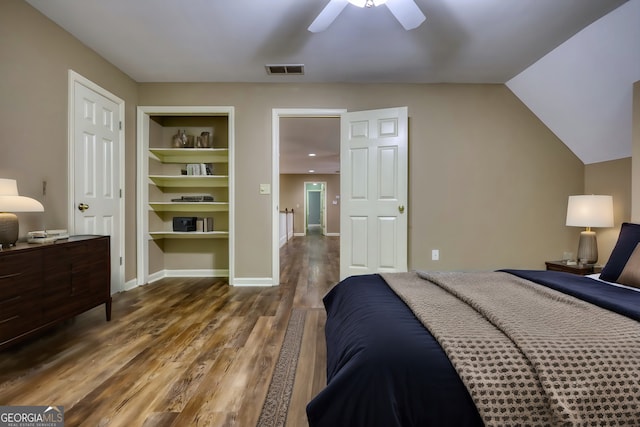 bedroom with baseboards, visible vents, a ceiling fan, dark wood-style floors, and vaulted ceiling