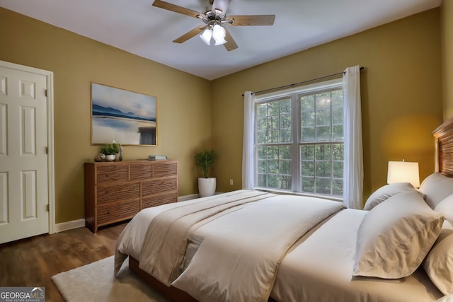 bedroom with ceiling fan, baseboards, and dark wood-style flooring