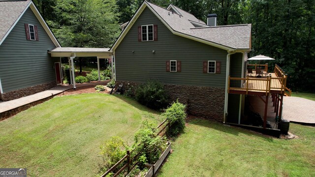 view of side of property featuring a lawn and a wooden deck