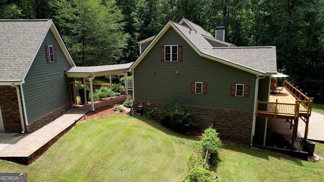 view of home's exterior with a deck and a yard