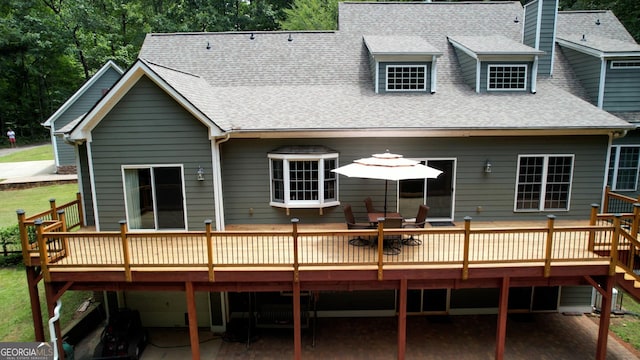 rear view of property featuring a deck and roof with shingles