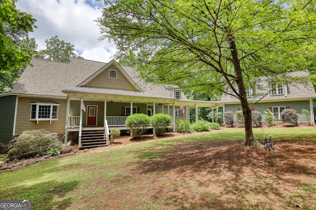 view of front facade with roof with shingles, a porch, and a front lawn