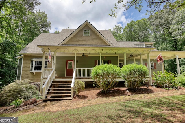 craftsman inspired home with a ceiling fan, stairway, roof with shingles, covered porch, and a front yard