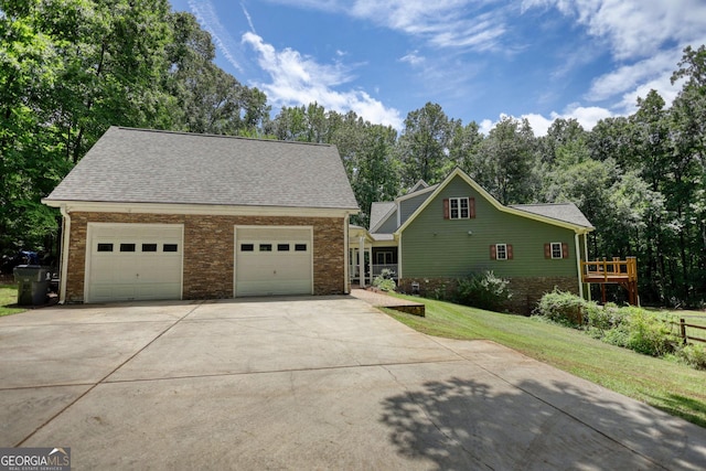 view of front of house featuring concrete driveway, a front lawn, and roof with shingles