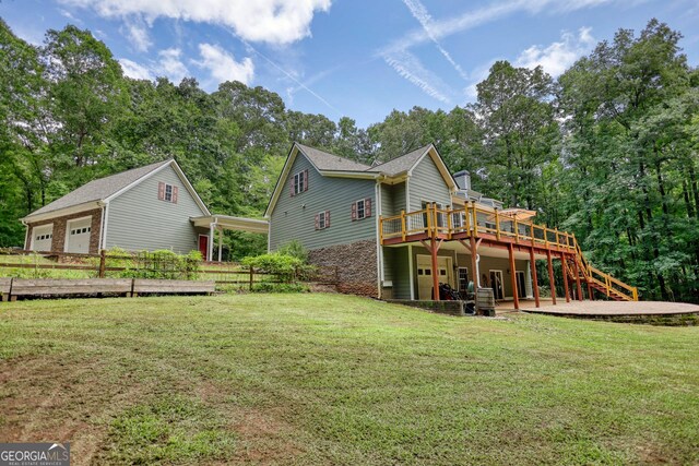 back of house featuring a deck and a yard