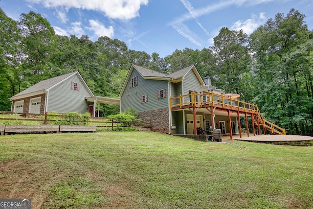 rear view of house featuring a deck, stairway, and a lawn