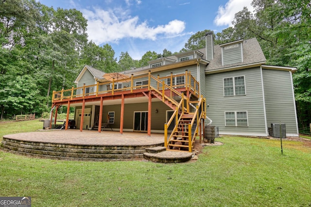 rear view of house with a patio, a wooden deck, central AC, and a yard