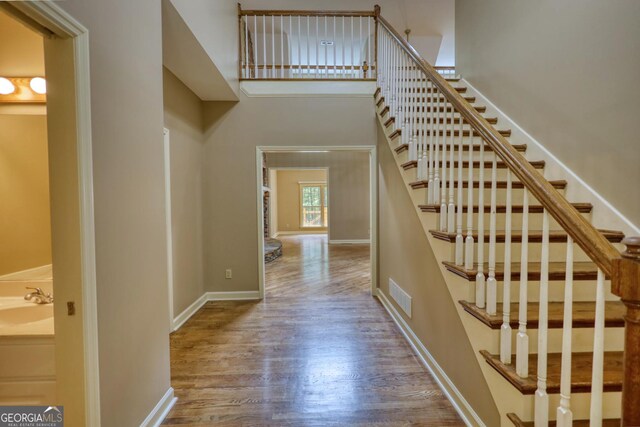 stairway with wood-type flooring and sink