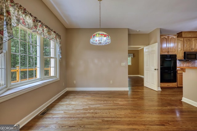 unfurnished dining area featuring light hardwood / wood-style floors and plenty of natural light