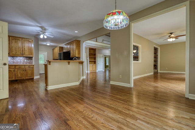 kitchen with a breakfast bar, pendant lighting, open floor plan, and freestanding refrigerator