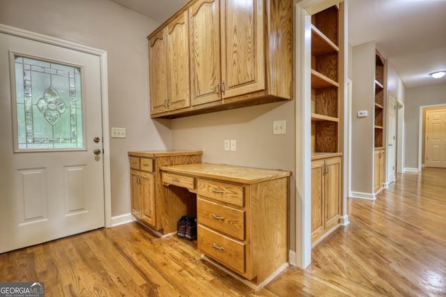 unfurnished office featuring baseboards and light wood-style floors