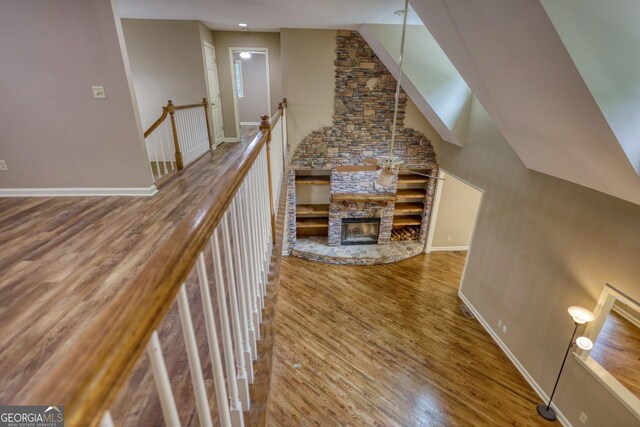 corridor with hardwood / wood-style flooring and a towering ceiling