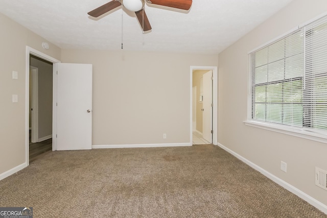 carpeted spare room featuring ceiling fan