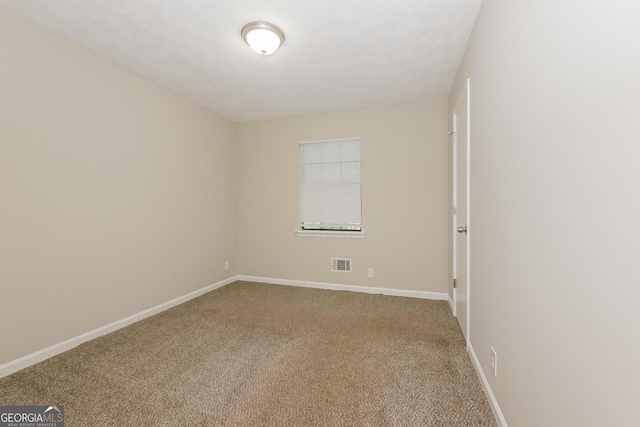 carpeted empty room featuring a textured ceiling