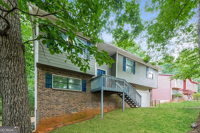 back of property featuring a garage, a wooden deck, and a yard